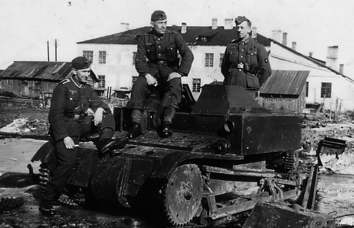 Немецкие содаты на фоне подбитой танкетки Т-27